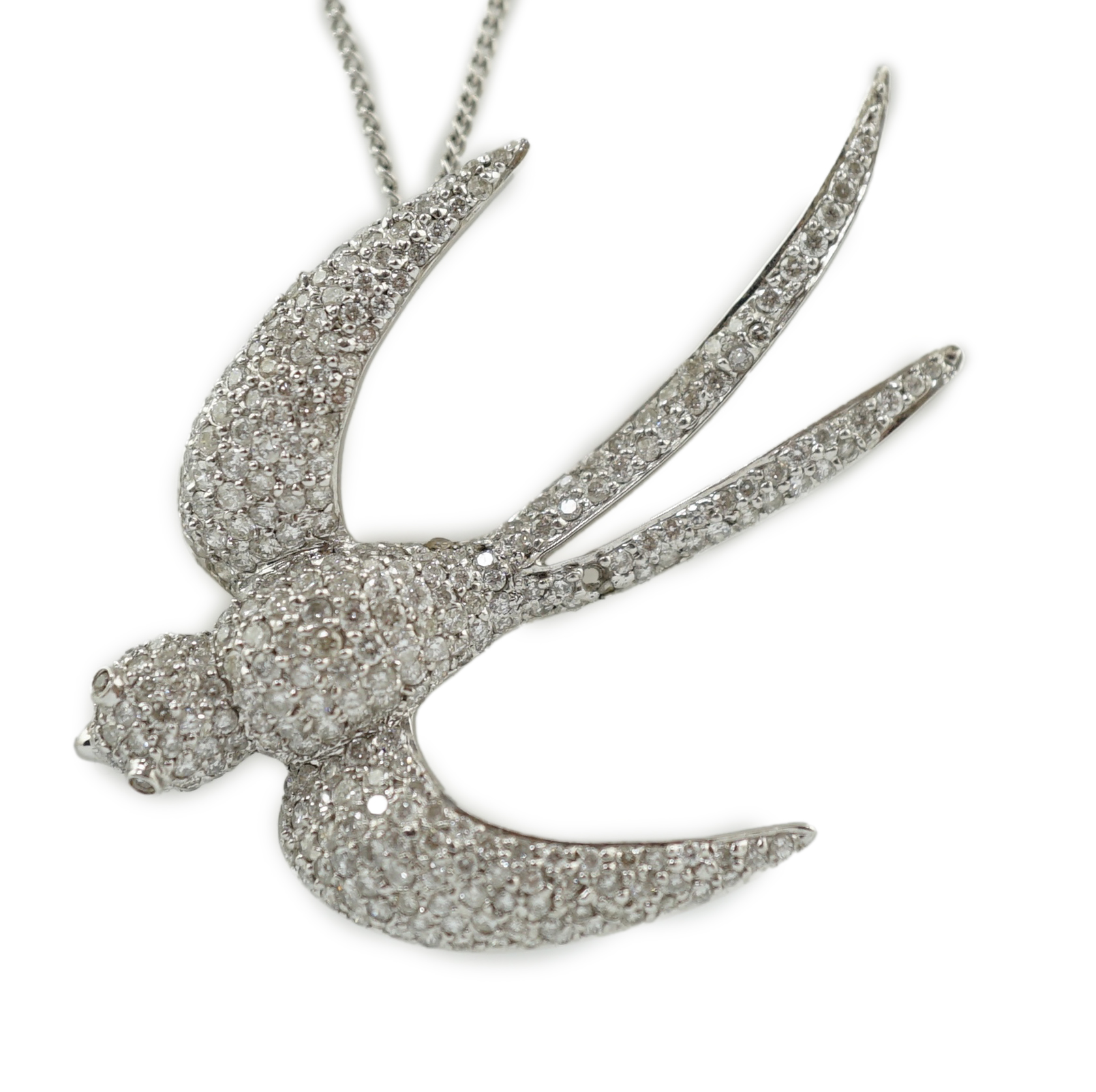 A modern 18k white gold and pavé set diamond pendant, modelled as a swallow, on an 18ct white gold fine link chain